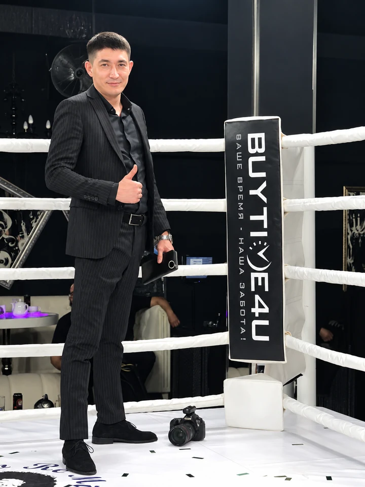 Нурлан Кусаинов, CEO BUYTIME4U, стоит у брендированной стойки компании на BUSHIDO Kazakhstan