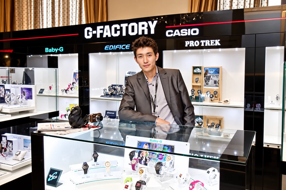 Нурлан Кусаинов стоит за брендированной стойкой Casio с наручными часами