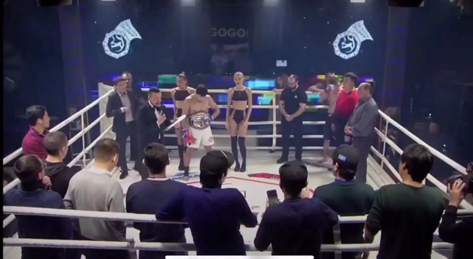 Бойцы и судья находятся на ринге BUSHIDO Kazakhstan, вокруг видны зрители